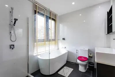 a bathroom with a tub and a toilet and a sink at Hideaway Lake Villas By Cozy Lake in Bang Tao Beach