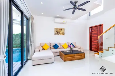 a living room with a couch and a ceiling fan at Hideaway Lake Villas By Cozy Lake in Bang Tao Beach