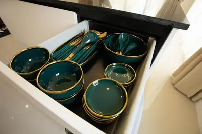 a drawer filled with green plates and silver utensils at Hideaway Lake Villas By Cozy Lake in Bang Tao Beach