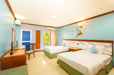 a hotel room with two beds and a television at Mayfa Hotel - SHA extra plus in Phuket Town