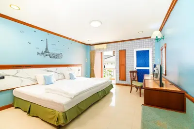 a large bedroom with a large bed and a desk at Mayfa Hotel - SHA extra plus in Phuket Town