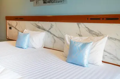 two blue pillows on a bed in a hotel room at Mayfa Hotel - SHA extra plus in Phuket Town