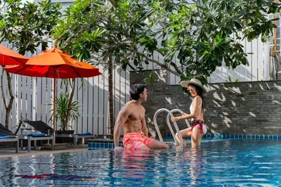 a man and a woman in a swimming pool at Citrus Patong Hotel by Compass Hospitality in Patong Beach