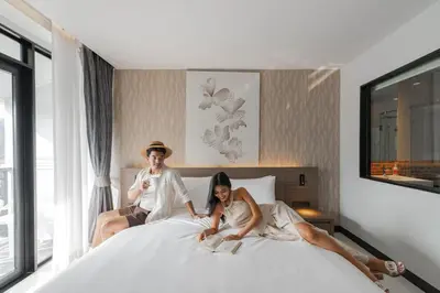a man and a woman laying on a bed at Citrus Patong Hotel by Compass Hospitality in Patong Beach