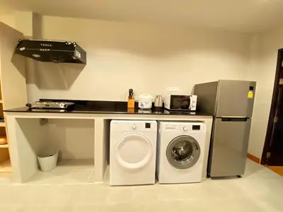 a kitchen with a washer and dryer in a room at The Nakara Town in Ban Rangeng