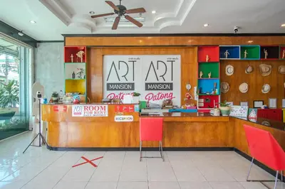 a restaurant with a counter with red chairs at Art Mansion Patong Hotel in Patong Beach