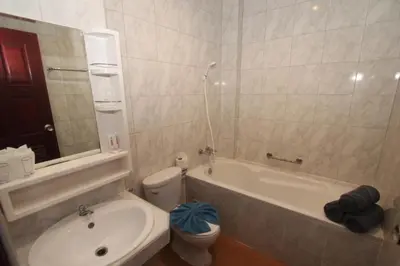a bathroom with a tub and a toilet and a sink at Art Mansion Patong Hotel in Patong Beach