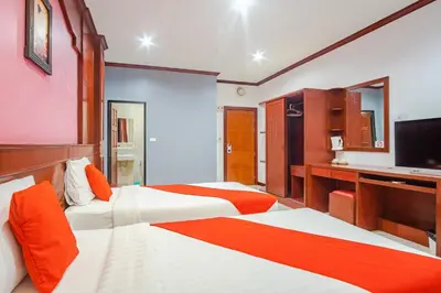 a hotel room with two beds and a flat screen tv at Art Mansion Patong Hotel in Patong Beach