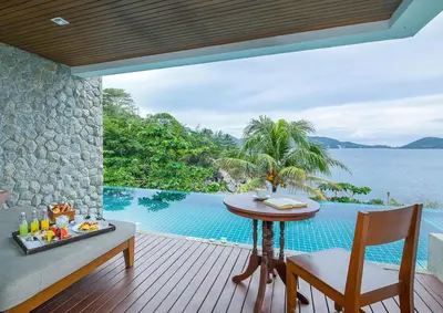 a patio with a table and a view of the water at Zenmaya Oceanfront Phuket, Trademark Collection by Wyndham in Patong Beach