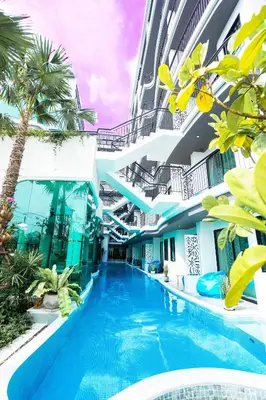 a swimming pool in the middle of a building with palm trees at Poolrada Boutique Hotel - SHA Plus in Thalang
