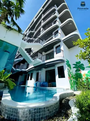 a building with a swimming pool in front of it at Poolrada Boutique Hotel - SHA Plus in Thalang
