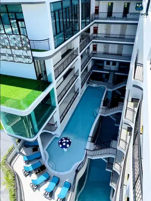 an apartment building with a swimming pool and chairs at Poolrada Boutique Hotel - SHA Plus in Thalang