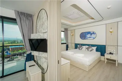 a bedroom with a bed and a tv and a balcony at Poolrada Boutique Hotel - SHA Plus in Thalang