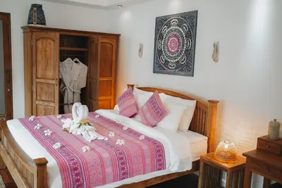 a bedroom with a bed with a red and white blanket at Soul Villas - Beachfront Private Pool Villas, Phuket Nature Retreat in Panwa Beach