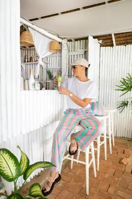 a man sitting in a chair holding a drink at Soul Villas - Beachfront Private Pool Villas, Phuket Nature Retreat in Panwa Beach