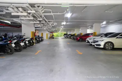 a parking garage filled with lots of parked cars at 2-Bedroom Apartment at Calypso Garden Residences in Rawai Beach