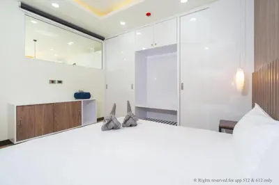 a bedroom with a large white bed with two pillows at 2-Bedroom Apartment at Calypso Garden Residences in Rawai Beach