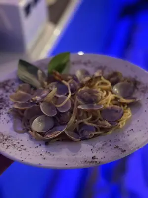 a plate of food with mussels and pasta on it at San Antonio Beach Guesthouse & Restaurant in Kata Beach
