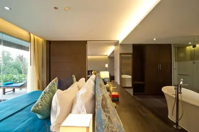 a bedroom with a blue bed and a tub and a room at Le Coral Resort in Natai Beach