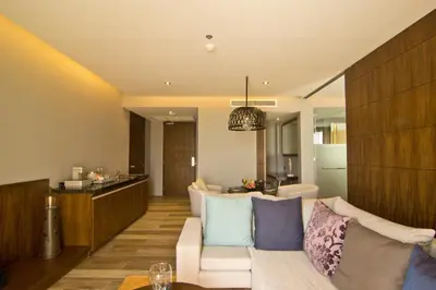 a living room with a white couch with pillows at Le Coral Resort in Natai Beach