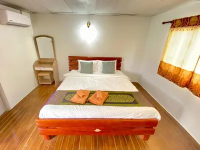 a bedroom with a bed with two orange pillows at Phi Phi Ba Kao Bay Resort in Phi Phi Don