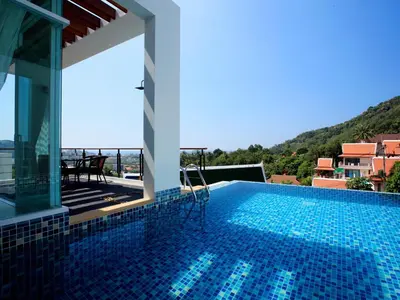 a swimming pool with a view of a house at Kata Sea View Villas in Kata Beach
