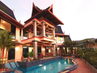 a large house with a swimming pool in front of it at Kata Sea View Villas in Kata Beach