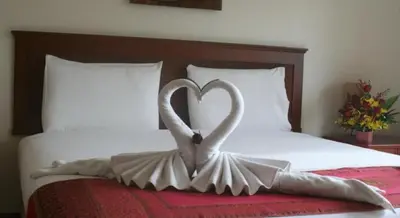 a sculpture of two swans forming a heart on a bed at Palmview Resort in Patong Beach
