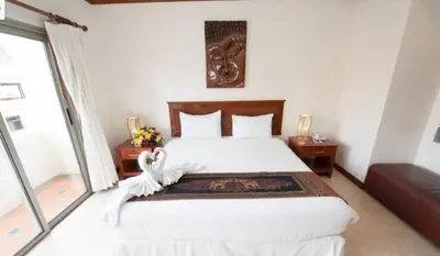 a bedroom with a bed and a large window at Palmview Resort in Patong Beach