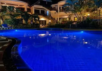 a swimming pool at night with blue lights at Beverly Hills Villa Patong in Patong Beach