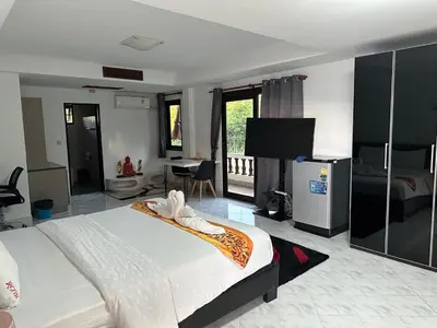 a hotel room with a bed and a television at Beverly Hills Villa Patong in Patong Beach