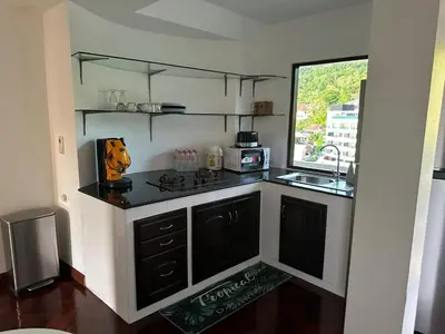 a small kitchen with a stove and a window at Beverly Hills Villa Patong in Patong Beach