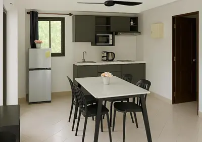 a kitchen with a table and chairs and a refrigerator at Beverly Hills Villa Patong in Patong Beach