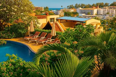 a pool with chairs and umbrellas next to a building at Beverly Hills Villa Patong in Patong Beach