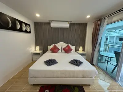 a bedroom with a bed with two pillows on it at Inn Dulgence in Patong Beach