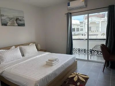 a bedroom with a bed with a view of a balcony at Inn Dulgence in Patong Beach