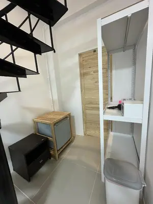 a small room with a tv and a shelf at Inn Dulgence in Patong Beach