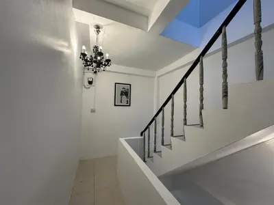 a staircase in a house with a chandelier at Inn Dulgence in Patong Beach