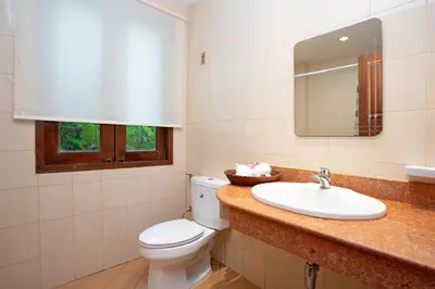 a bathroom with a toilet and a sink and a mirror at Heavenly Villas in Patong Beach