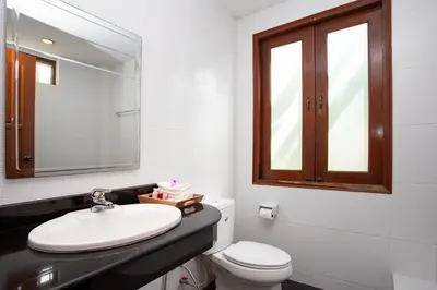a bathroom with a sink and a toilet and a mirror at Heavenly Villas in Patong Beach