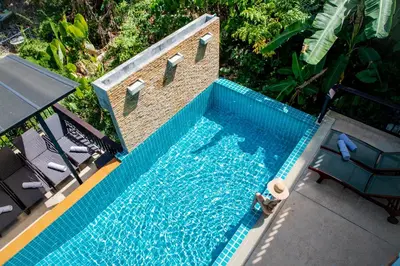 an overhead view of a swimming pool with two chairs at Heavenly Villas in Patong Beach