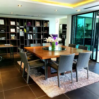 a dining room table with chairs and a vase of flowers at Eden Villa Phuket in Bang Tao Beach
