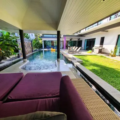 a swimming pool with purple furniture in a house at Eden Villa Phuket in Bang Tao Beach