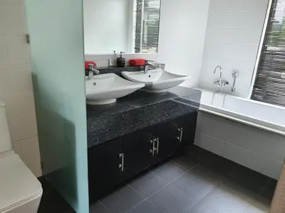 a bathroom with two sinks and a toilet and a mirror at Eden Villa Phuket in Bang Tao Beach