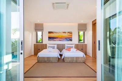 two beds in a room with two windows at Shambhala Grand Villa - Private Pool Villas by Escape Villas - Top Choice - Guest Favorite - Best Location in Bang Tao Beach