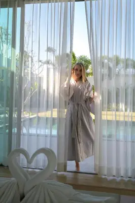 a woman standing in front of a window at Shambhala Grand Villa - Private Pool Villas by Escape Villas - Top Choice - Guest Favorite - Best Location in Bang Tao Beach