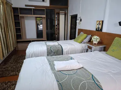 a hotel room with two beds with towels on them at Suwita House in Nai Yang Beach