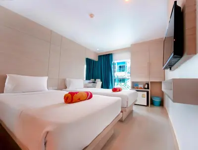 a hotel room with two beds and a flat screen tv at Mirage Express Patong Phuket Hotel in Patong Beach