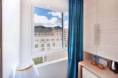 a room with a window with a view of a building at Mirage Express Patong Phuket Hotel in Patong Beach