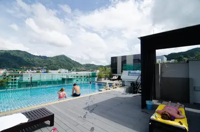 two people in a swimming pool on top of a building at Mirage Express Patong Phuket Hotel in Patong Beach